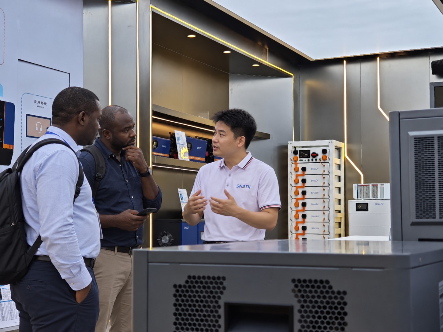 Solar Distributor Partnership Discussion | SNAT Solar solar-distribSNAT Solar representative discussing distributor partnership with African business partners in a solar energy showroomutor-partnership-discussion-showroom