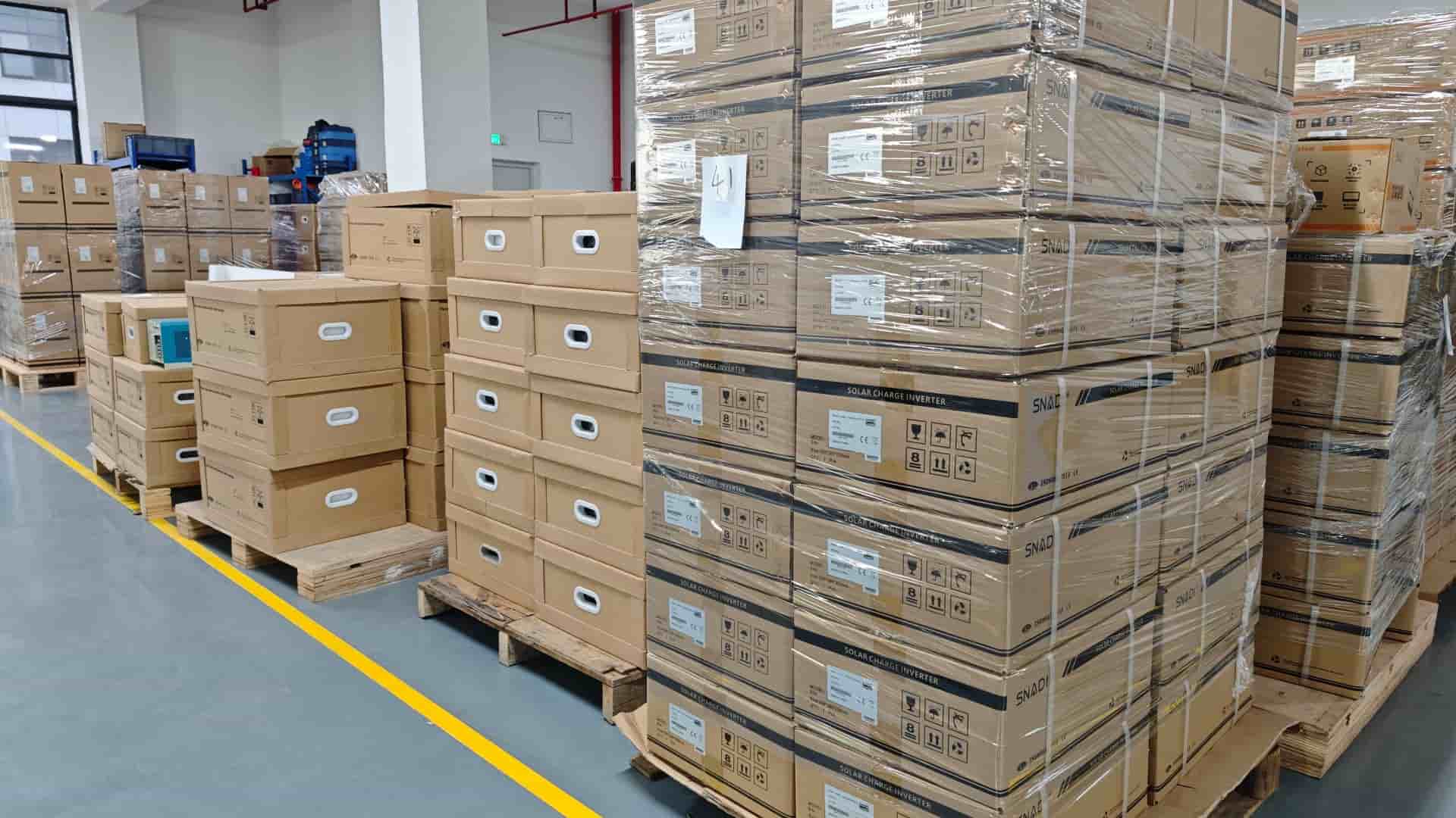Grandes cantidades de inversores de carga solar y productos energéticos de la marca SNADI embalados en cajas de cartón